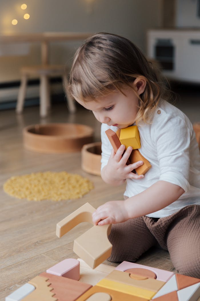 Home Young child playing with wooden blocks indoors, showcasing innocence and creativity.