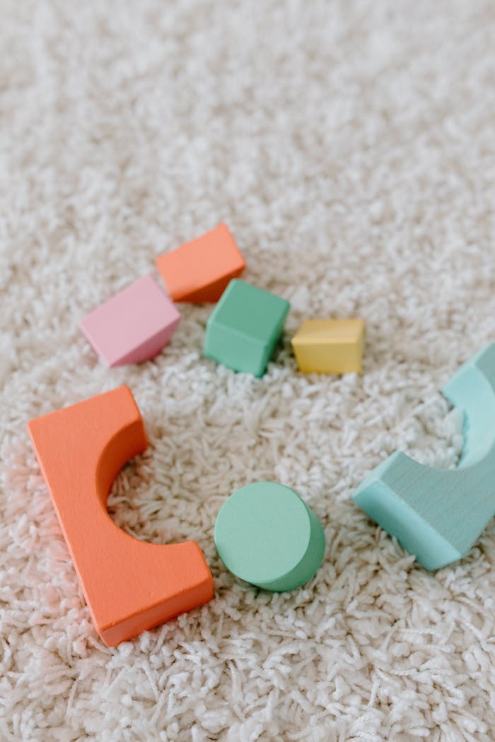 Vibrant wooden educational toys scattered on a soft beige carpet.