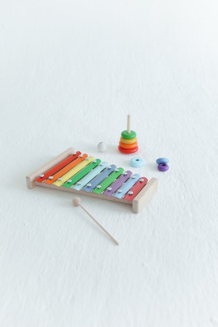 A vibrant xylophone and ring stacking toy on a minimalist white background.