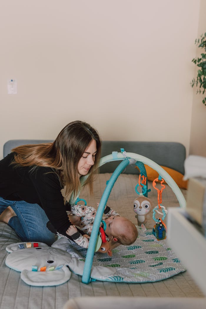 A mother interacts with her baby on a play mat, promoting bonding and development indoors.