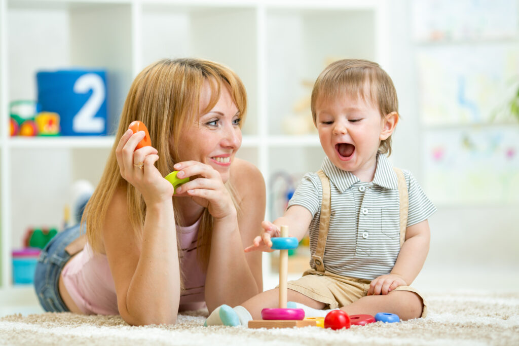 parent and baby boy playing together at home